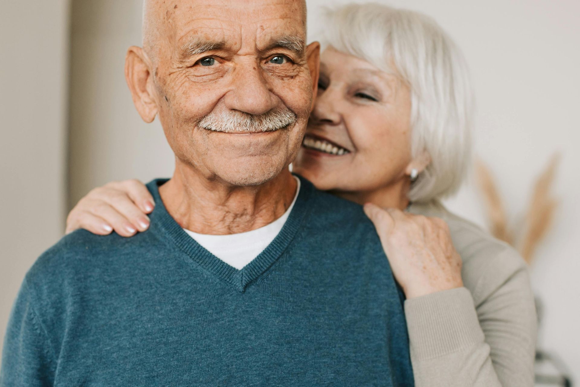 A woman is kissing an older man on the cheek.