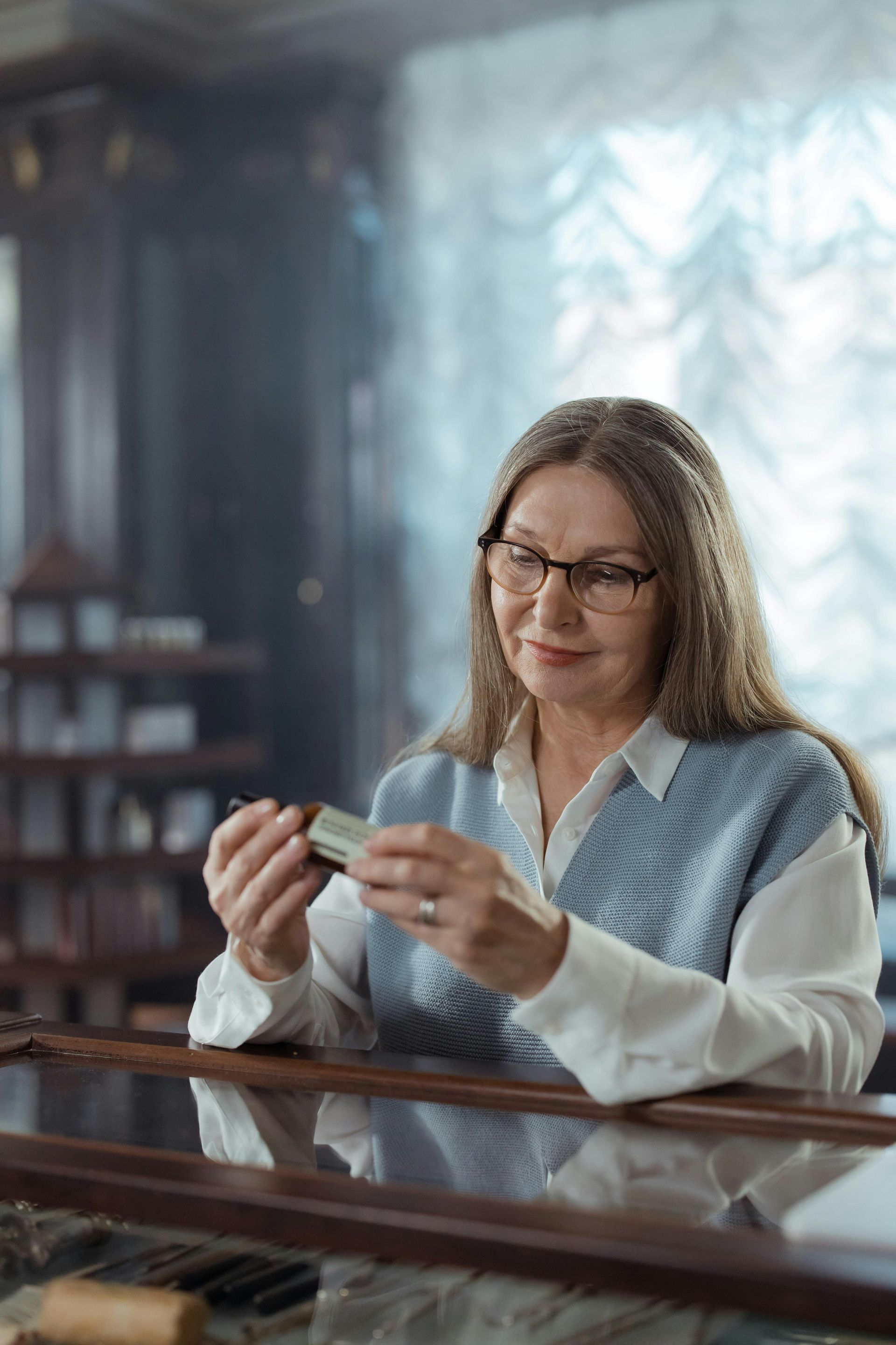 A woman is sitting at a counter holding a piece of money.