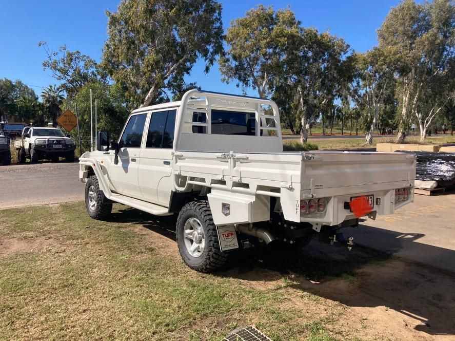 A White Truck With a Tray on the Back is Parked in a Grassy Area — Emerald 4x4 in Emerald, QLD
