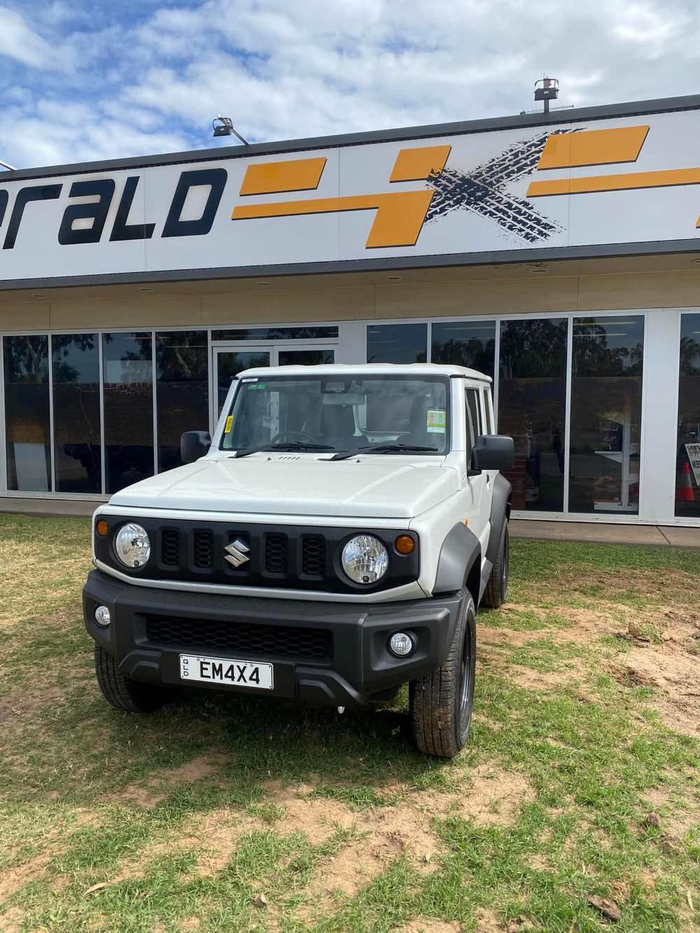 A White Suzuki Jimny is Parked in Front of a Building — Emerald 4x4 in Emerald, QLD