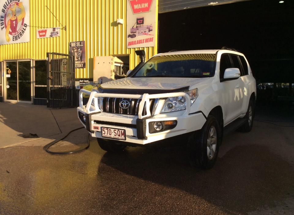 A White Suv is Parked in Front of a Yellow Building — Emerald 4x4 in Blackwater, QLD