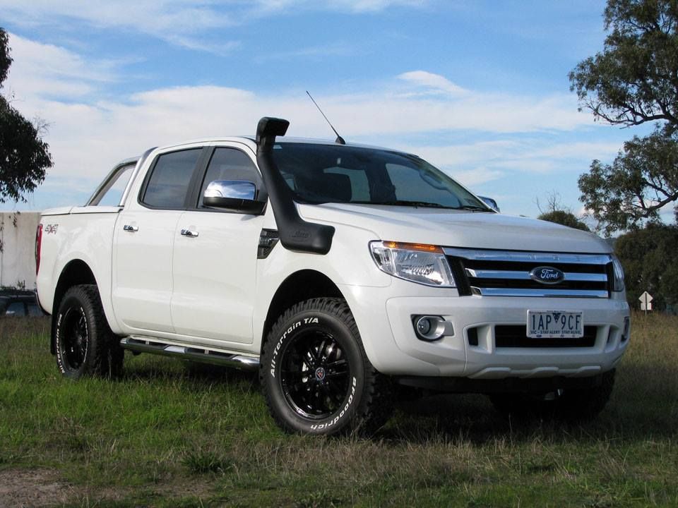 A White Ford Truck With a Snorkel is Parked in a Grassy Field — Emerald 4x4 in Springsure, QLD