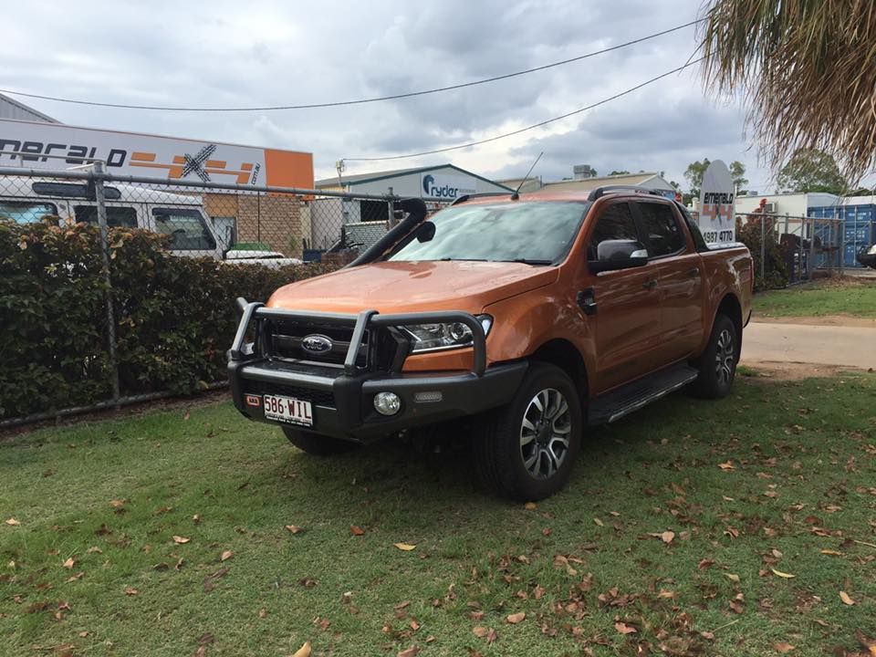 A Ford Ranger is Parked in a Grassy Area in Front of a Building — Emerald 4x4 in Rolleston, QLD