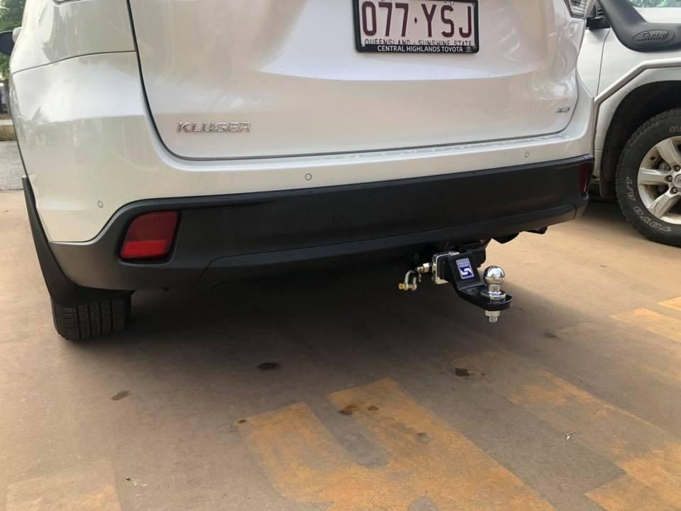 A White Suv With a Tow Bar Attached to the Back of It is Parked in a Parking Lot — Emerald 4x4 in Emerald, QLD