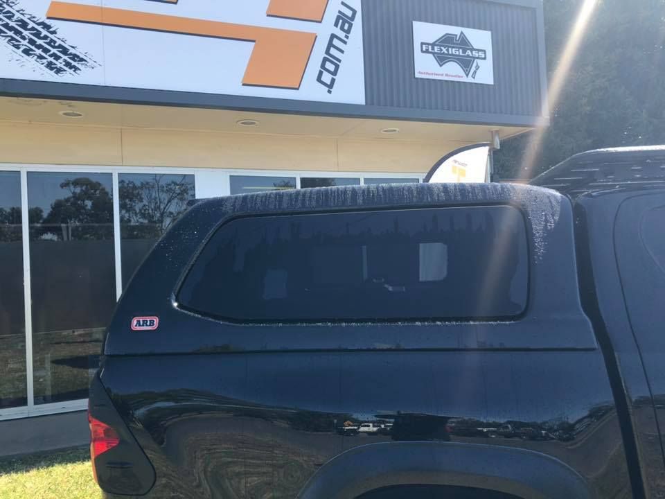 A Black Truck With a Canopy on Top of It is Parked in Front of a Building — Emerald 4x4 in Emerald, QLD
