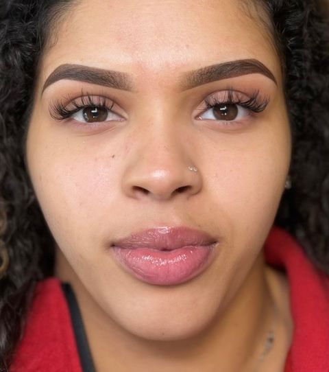 A close up of a woman 's face with a red shirt on