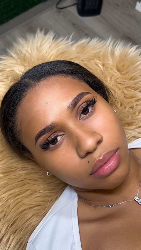 A close up of a woman laying on a fur blanket.