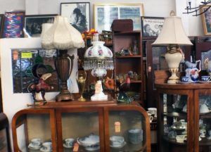 A room filled with lots of lamps and a glass cabinet.