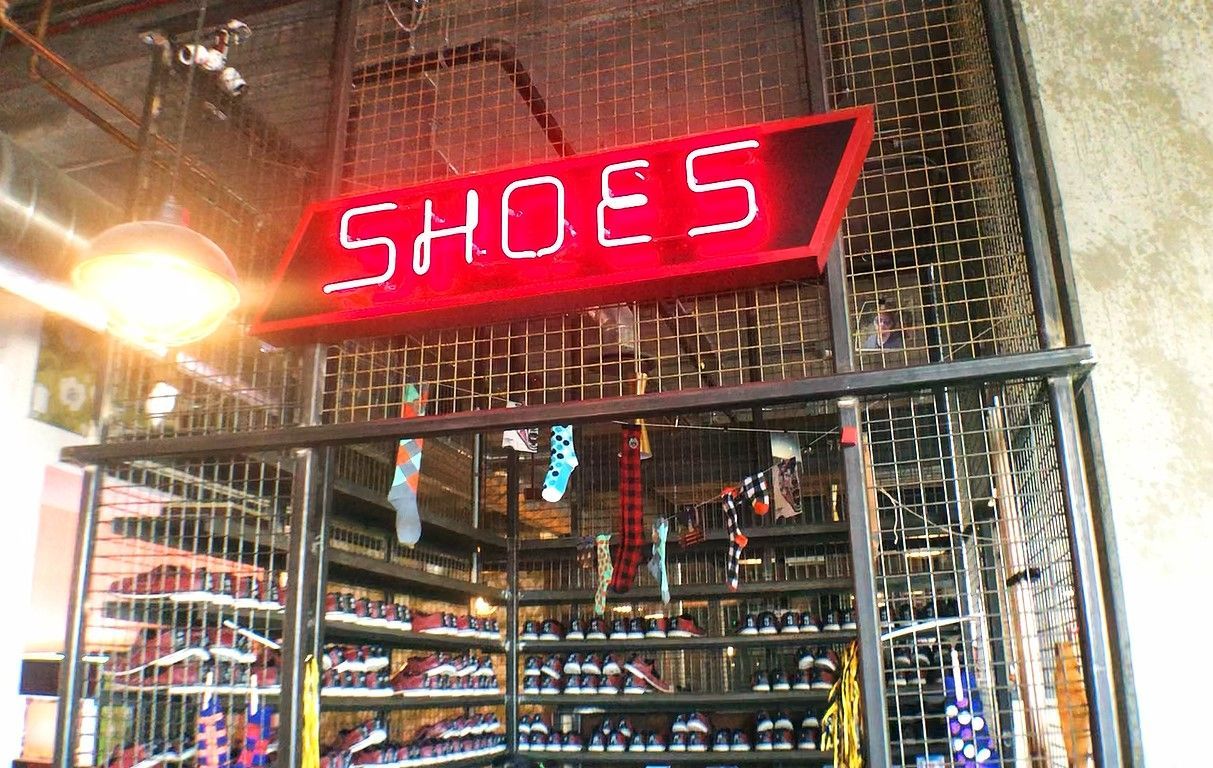 A shoe store with a neon sign that says shoes