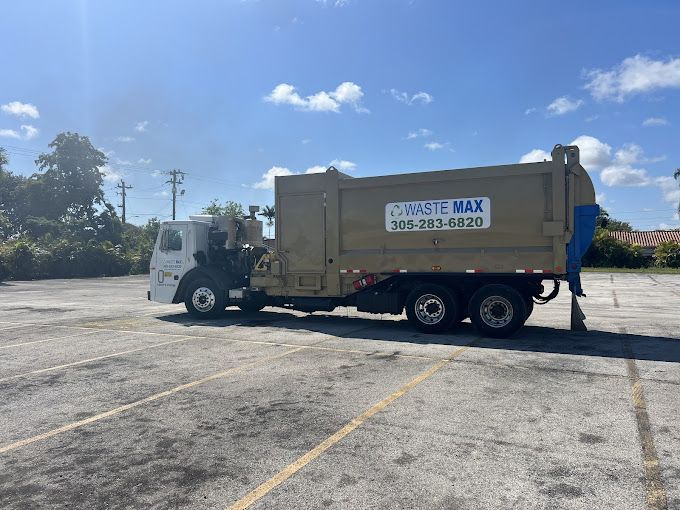 A garbage truck is parked in a parking lot.