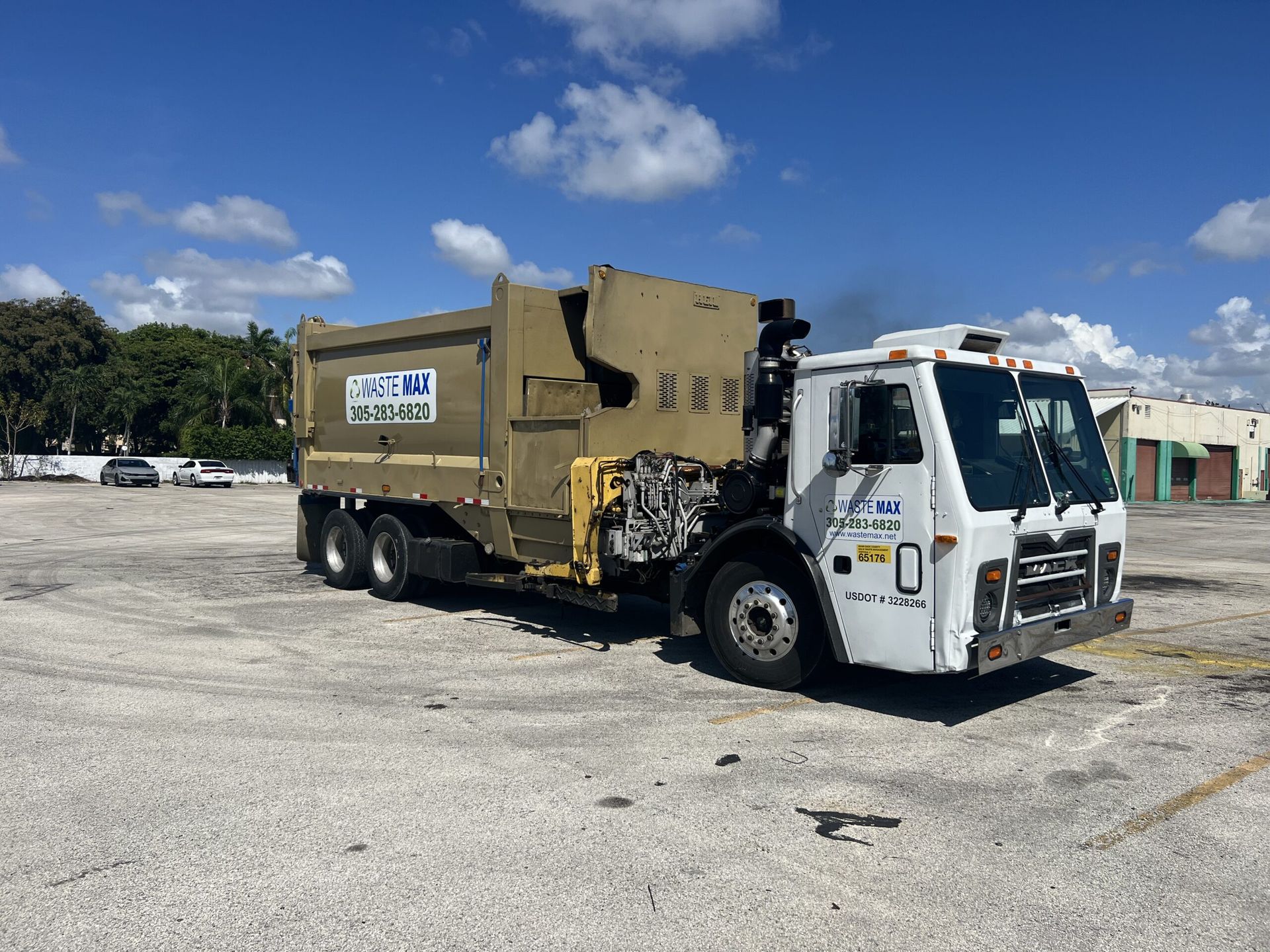 A garbage truck is parked in a parking lot.