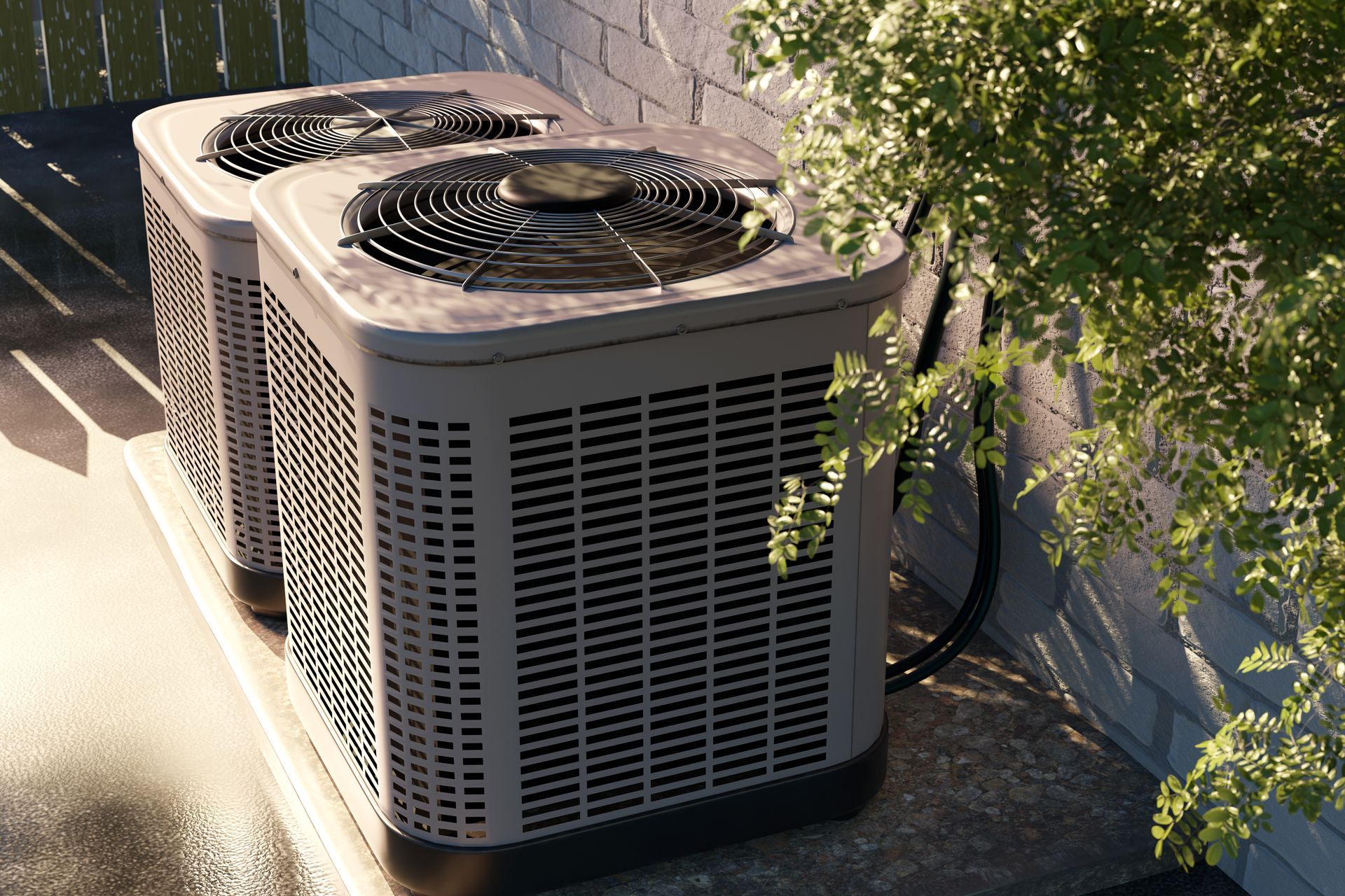 Two beige air conditioning units outside, near a white wall and green foliage.
