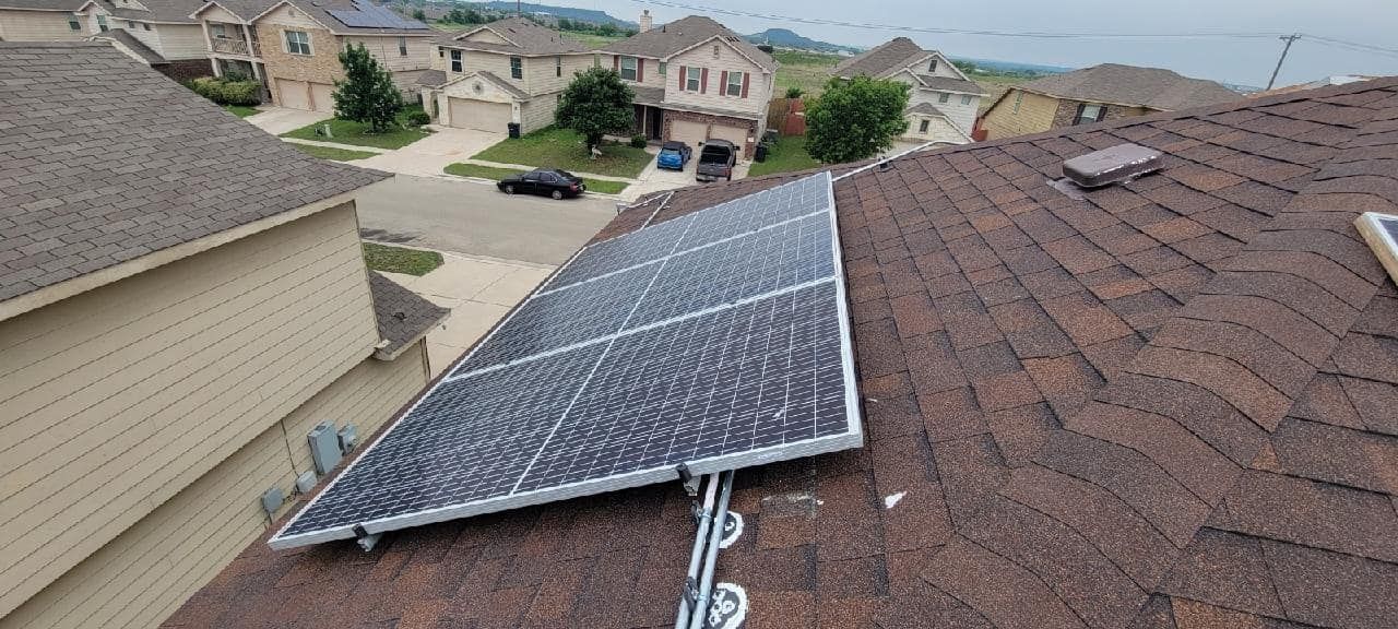 A solar panel is mounted on the roof of a house.