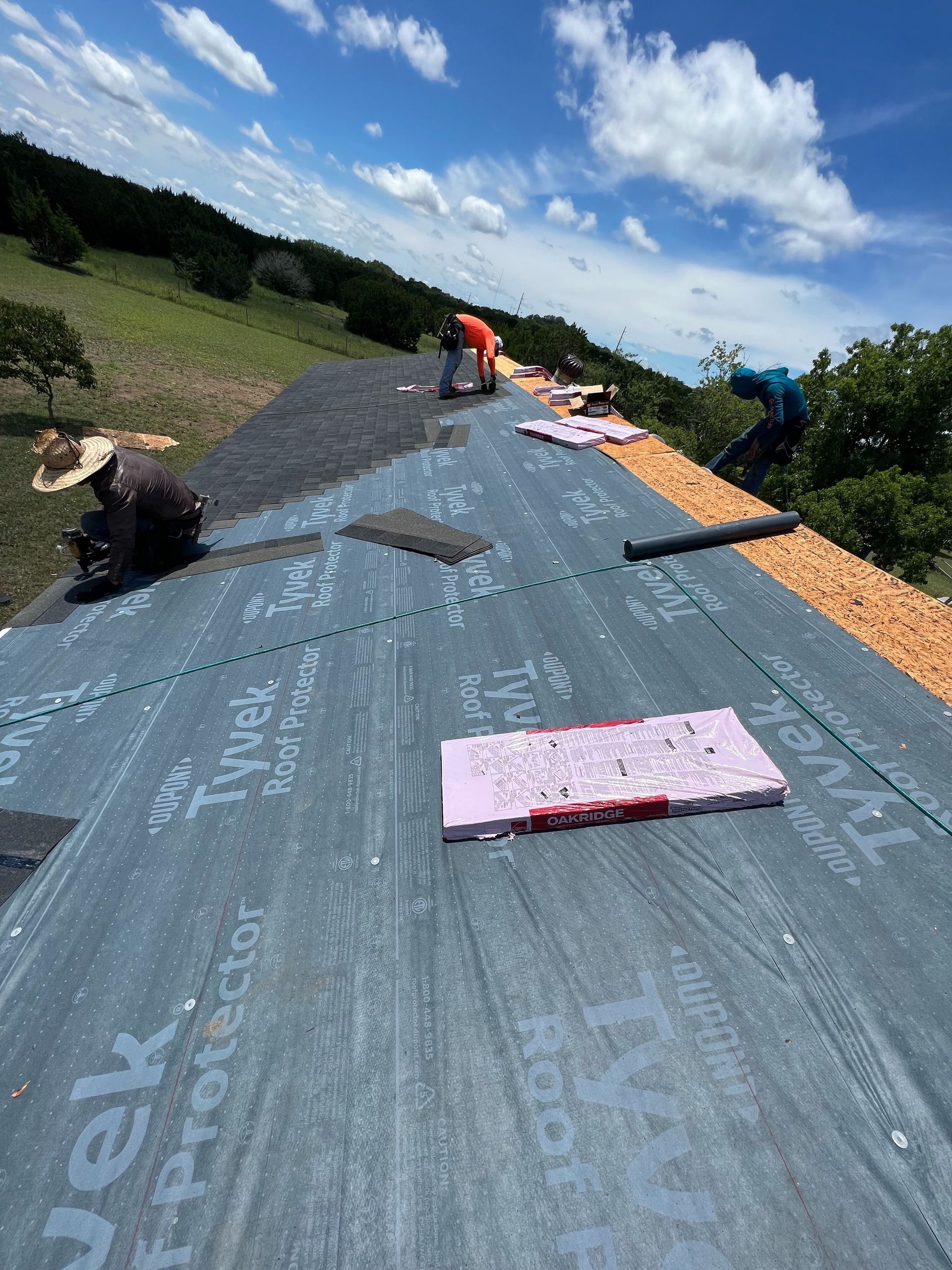 A man is working on a roof with a tarp on it.