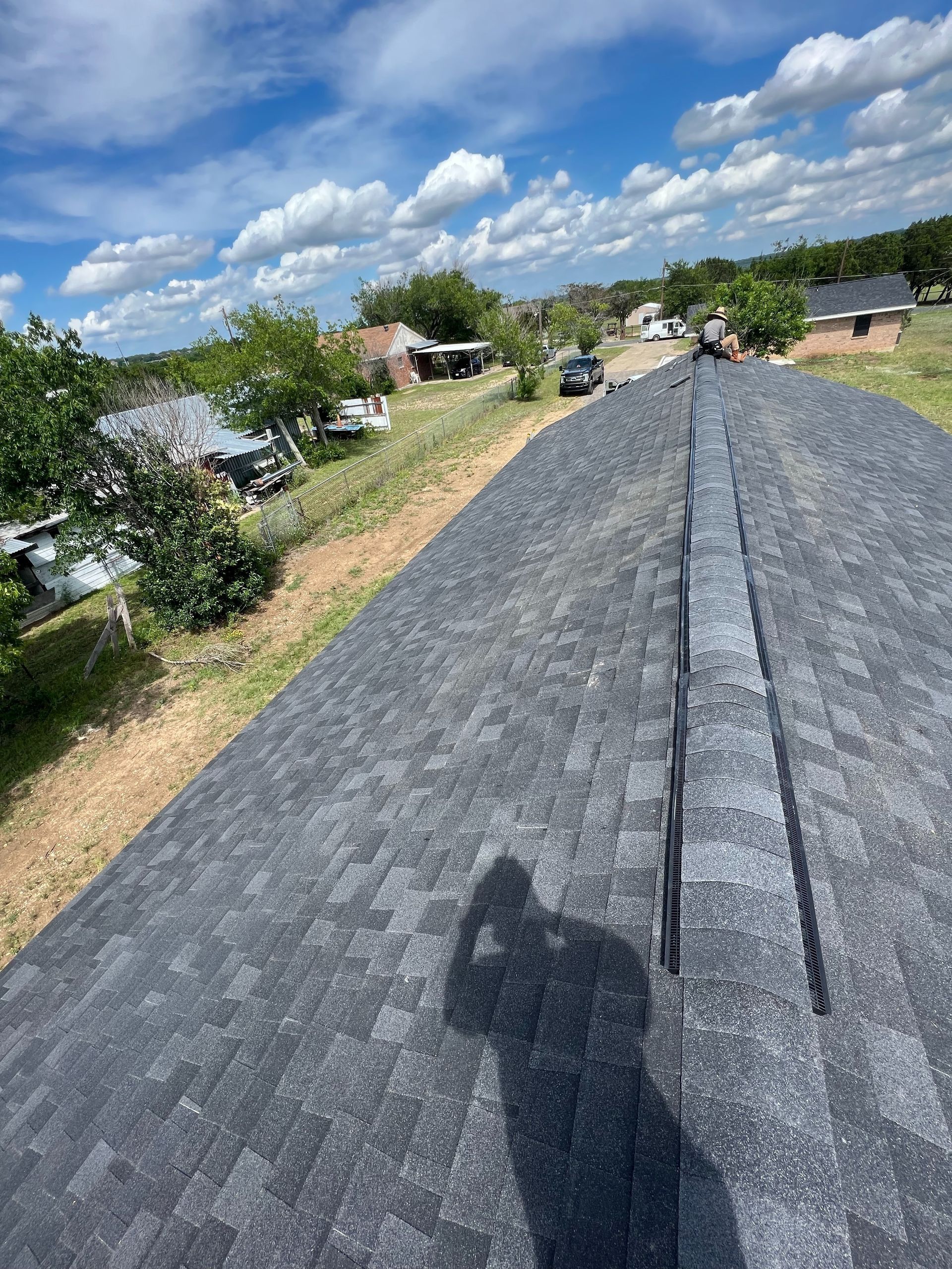 A shadow of a person is cast on the roof of a house.