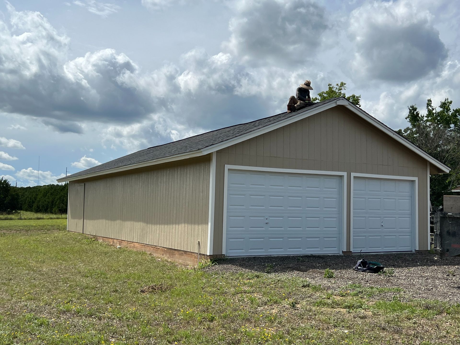 A man is working on the roof of a garage.