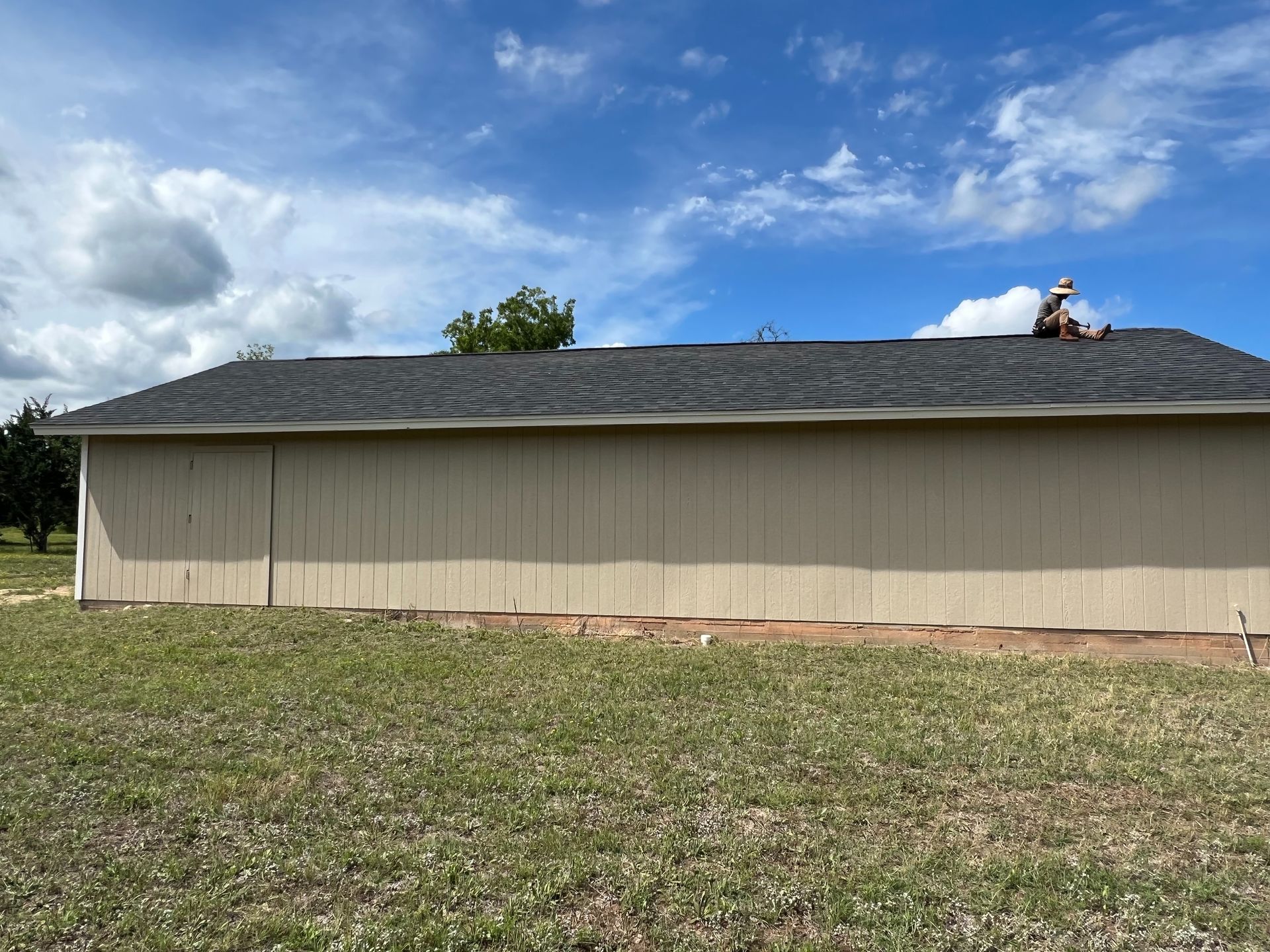 A man is working on the roof of a house.