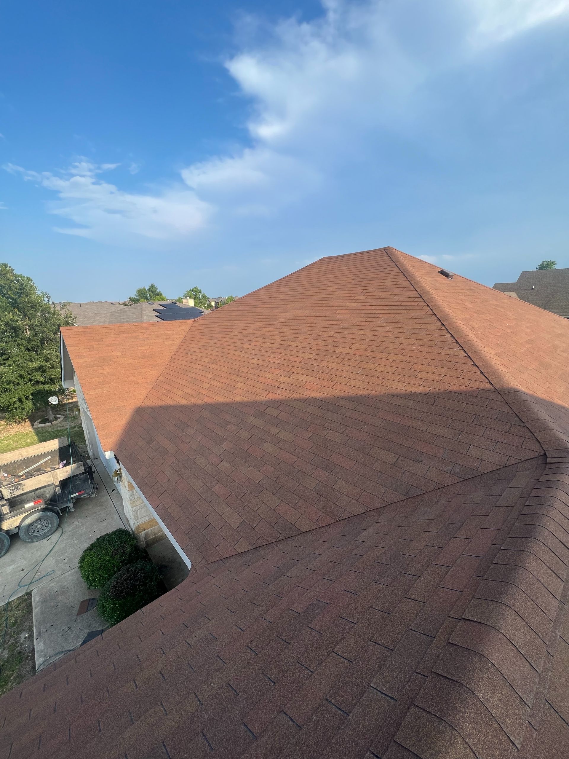 A house with a red roof and a blue sky in the background.