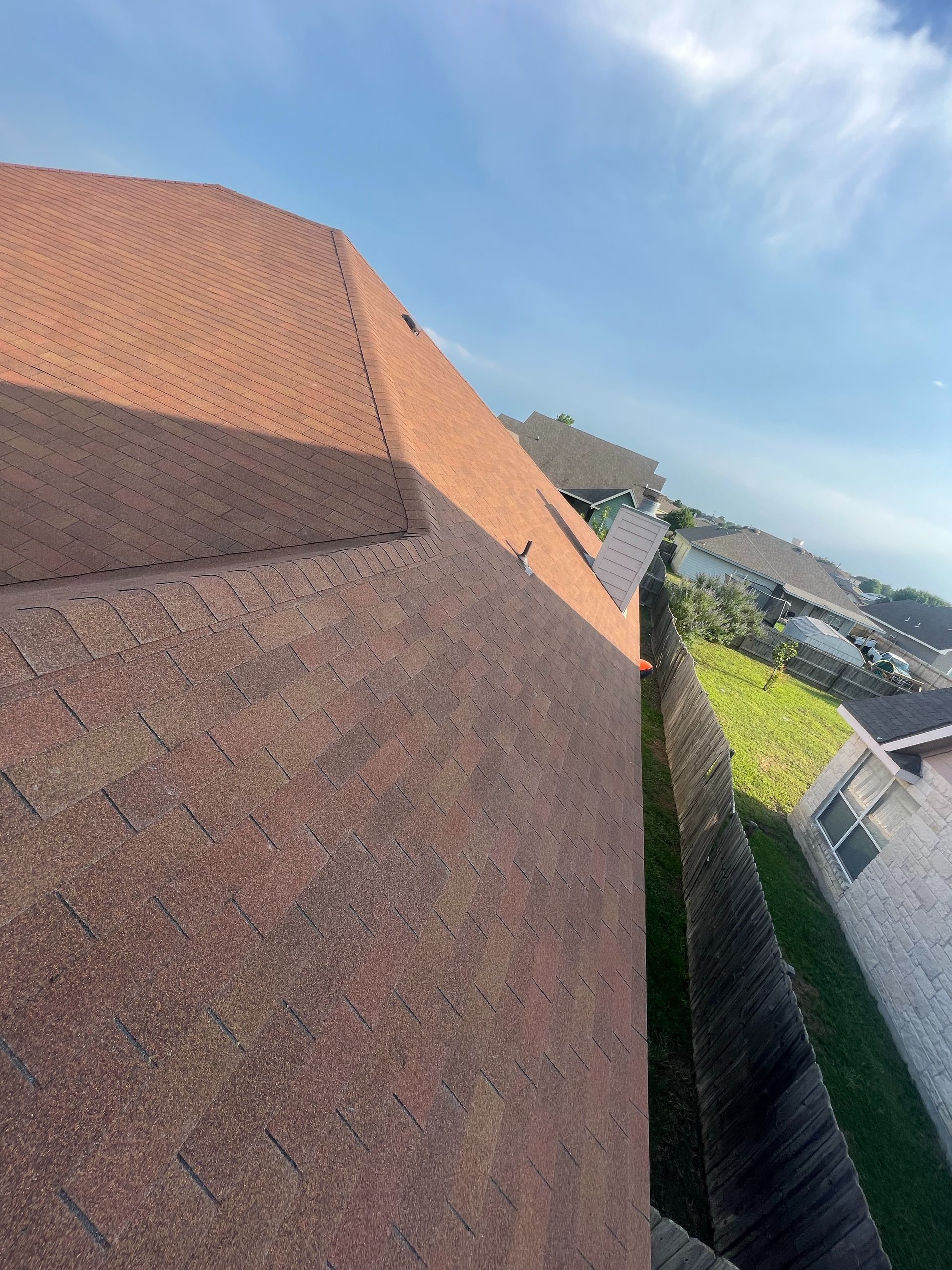 A close up of a roof with a fence in the background.