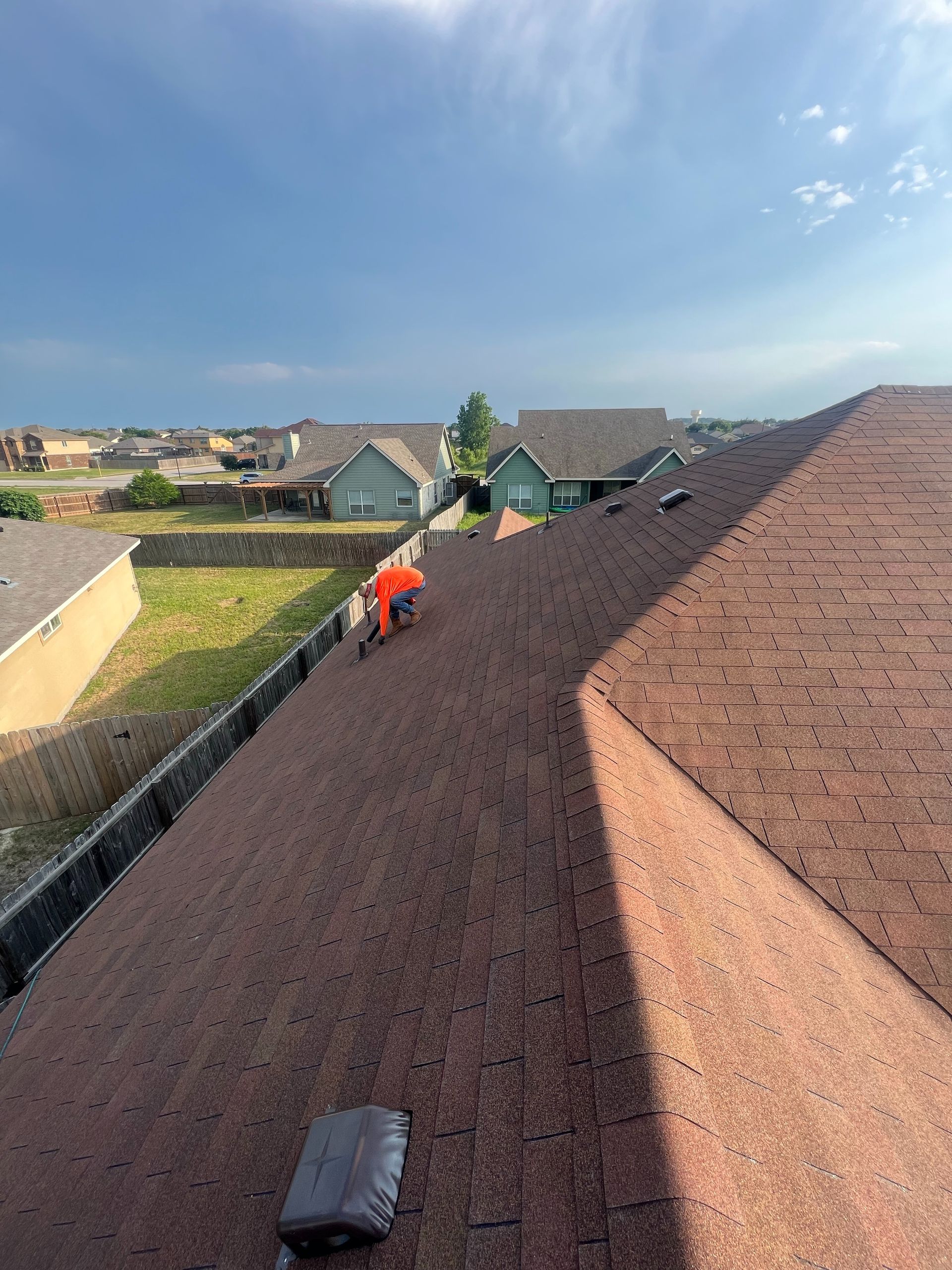 A man is working on the roof of a house.