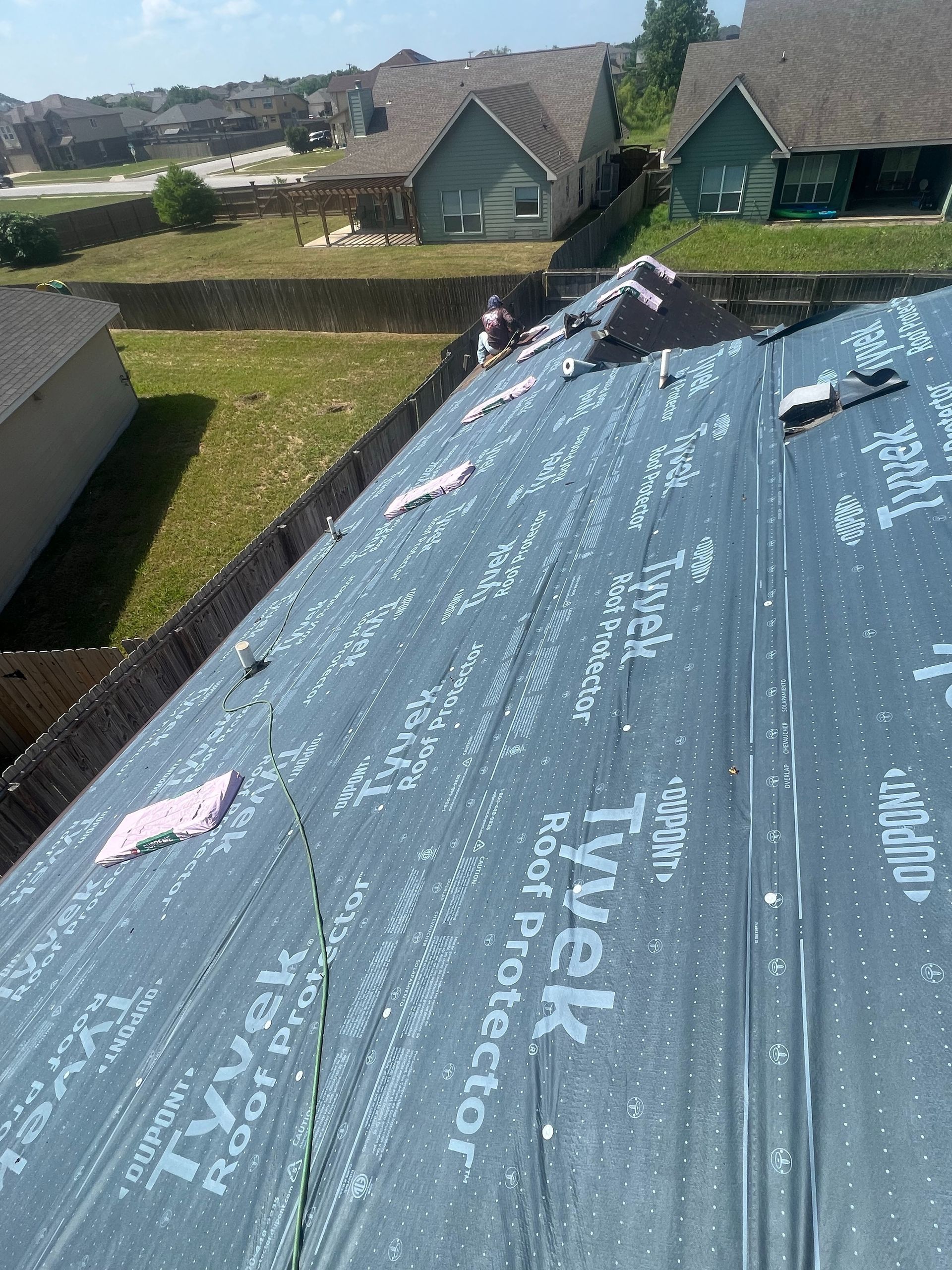 A tyvek roof protector is being installed on a roof