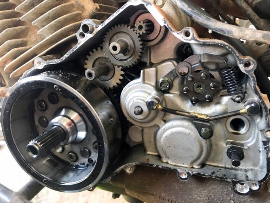 Motorcycle engine interior showing gears, rotor, and starter mechanism.