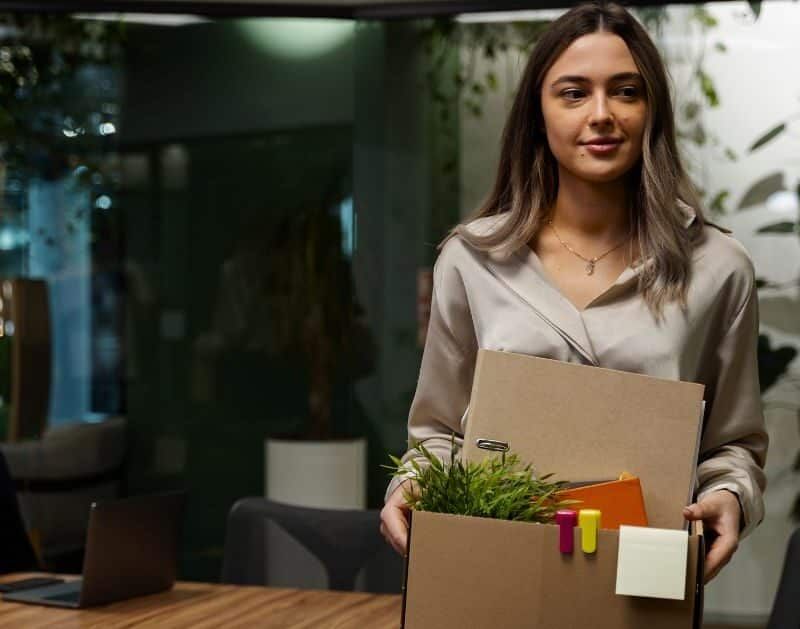 A woman is holding a box with her belongings in it.