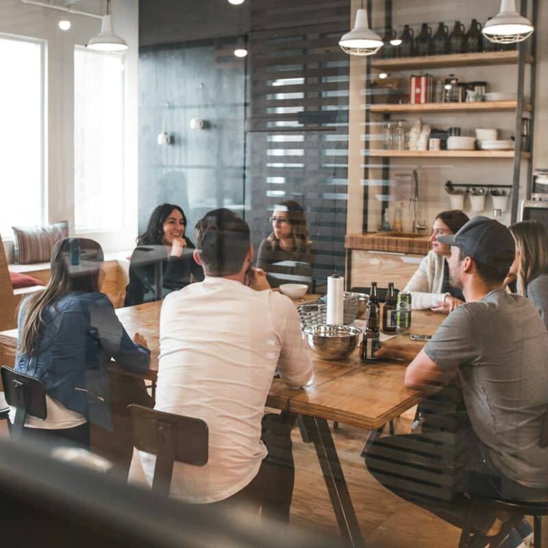 A group of people are sitting around a table in a restaurant.