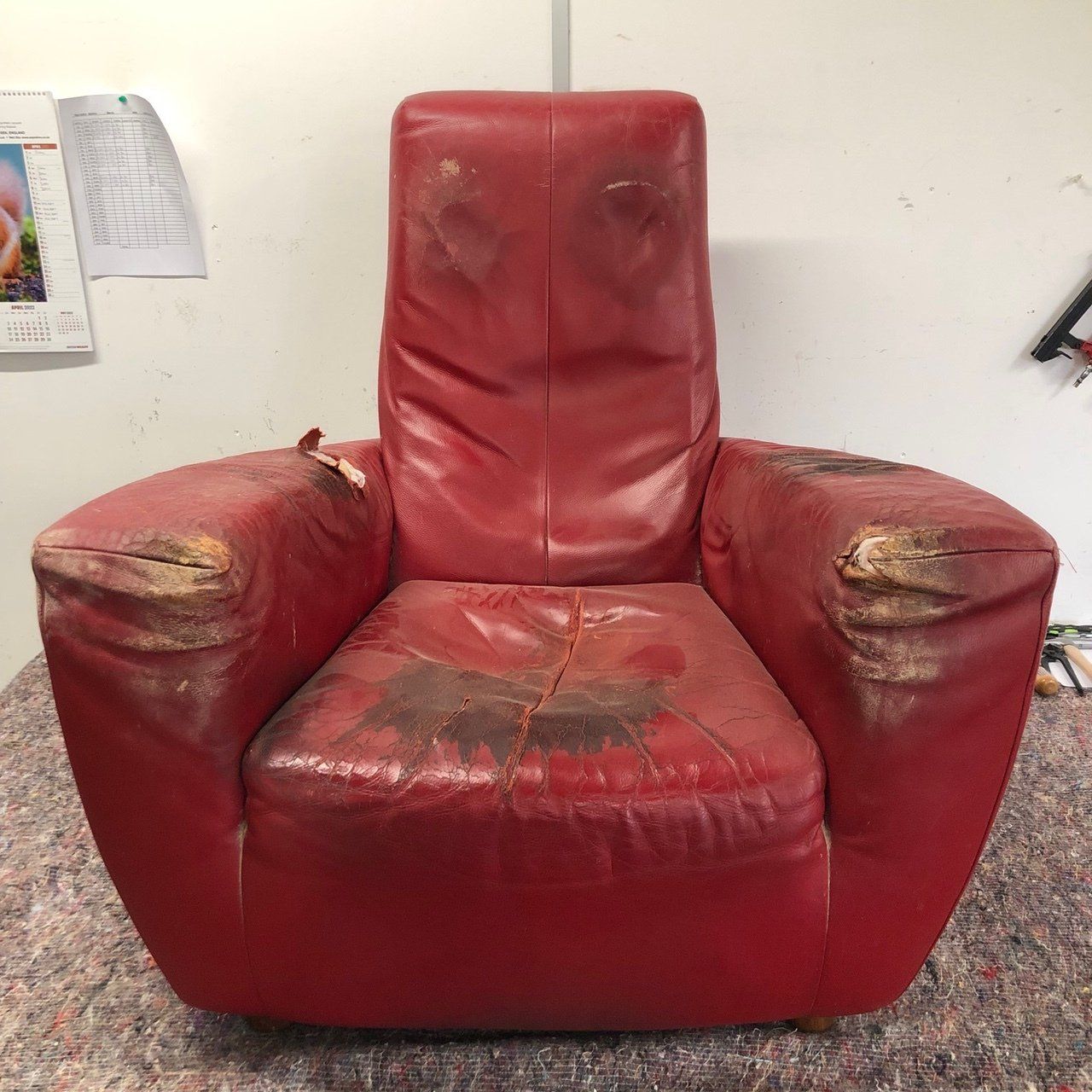Scruffy big red leather armchair before