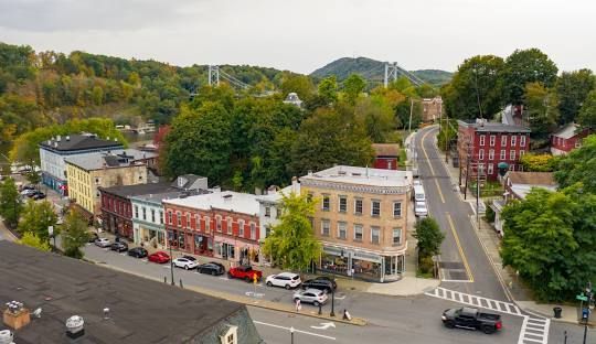 A park with a blue pavilion and a large lawn.