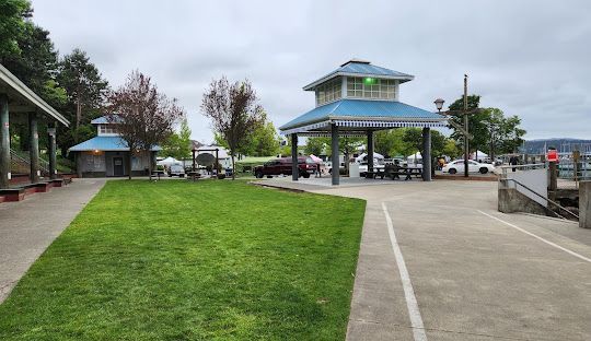 A park with a blue pavilion and a large lawn.