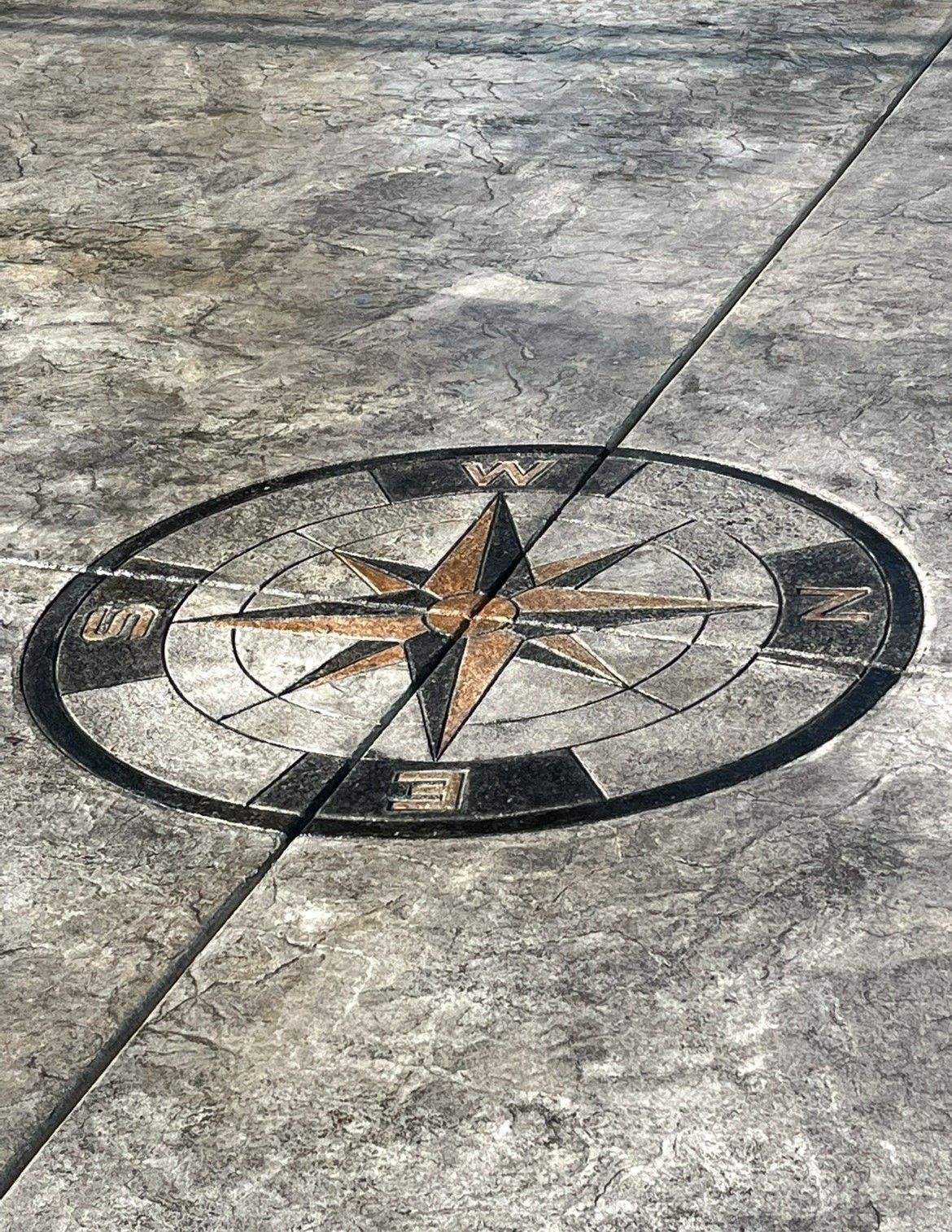A close up of a compass on a concrete floor.