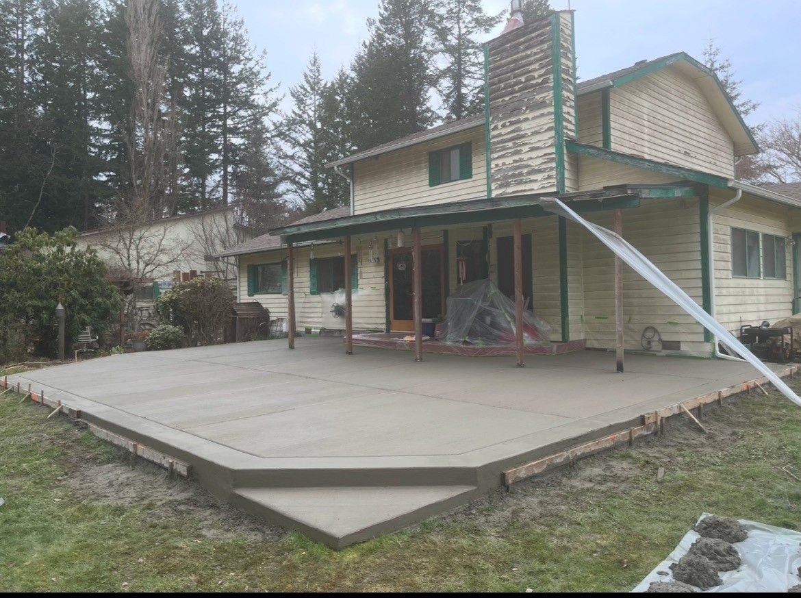 A large house with a concrete patio in front of it.