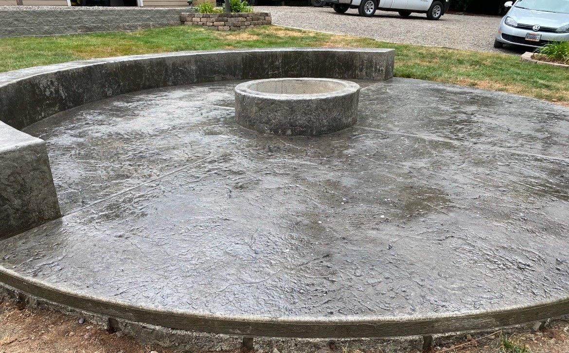 A concrete circle with a fire pit in the middle of it.
