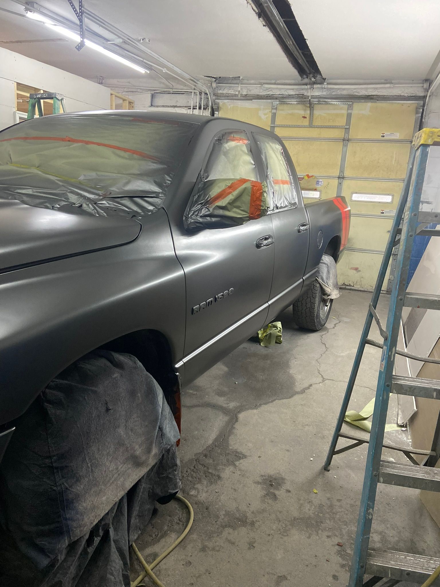 A Black Truck Is Parked in A Garage Next to A Ladder — Chicago, IL — Ecuamex Autobody Inc.