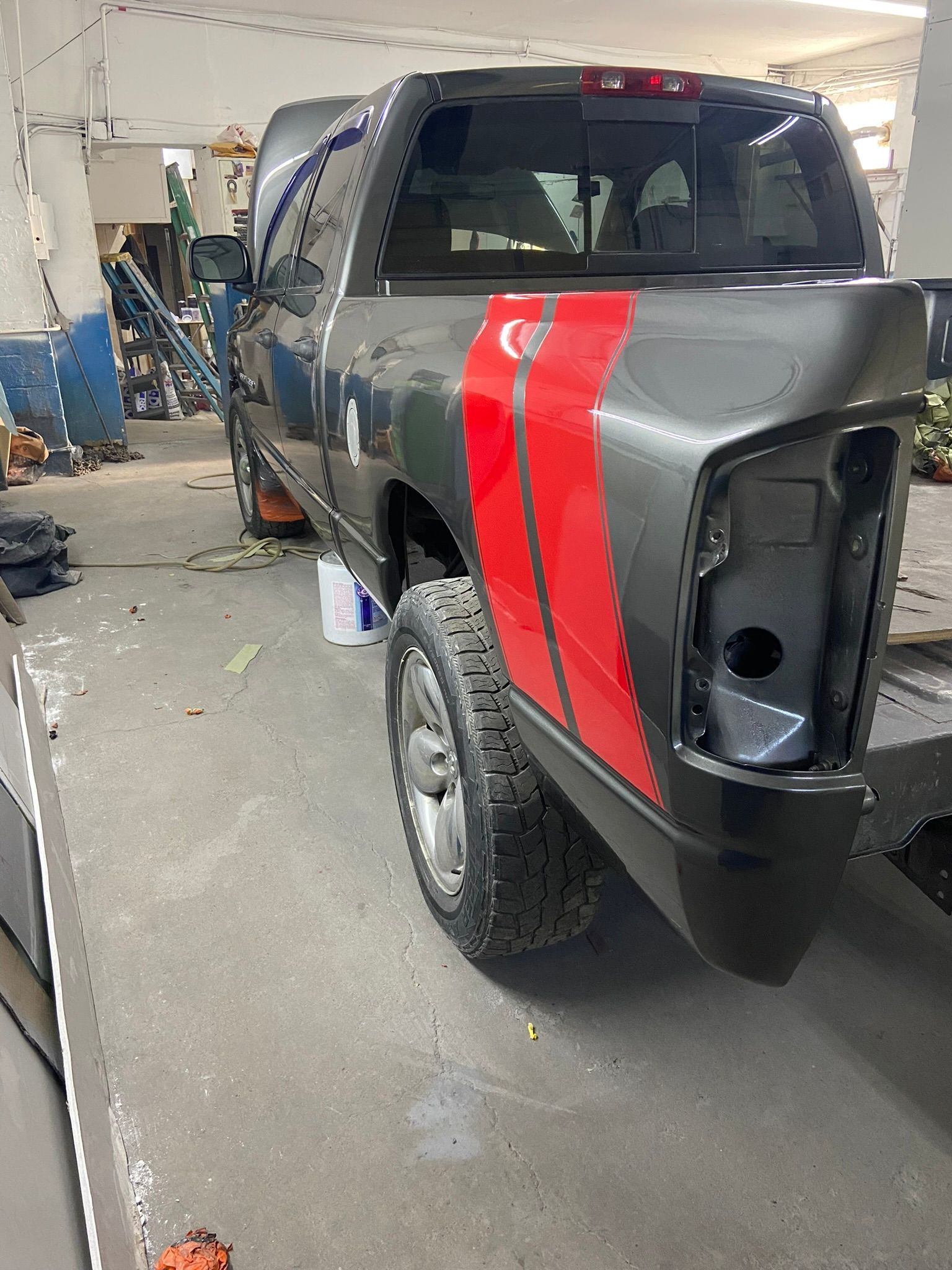 A Black Truck with A Red Stripe on The Side Is Parked in A Garage — Chicago, IL — Ecuamex Autobody Inc.