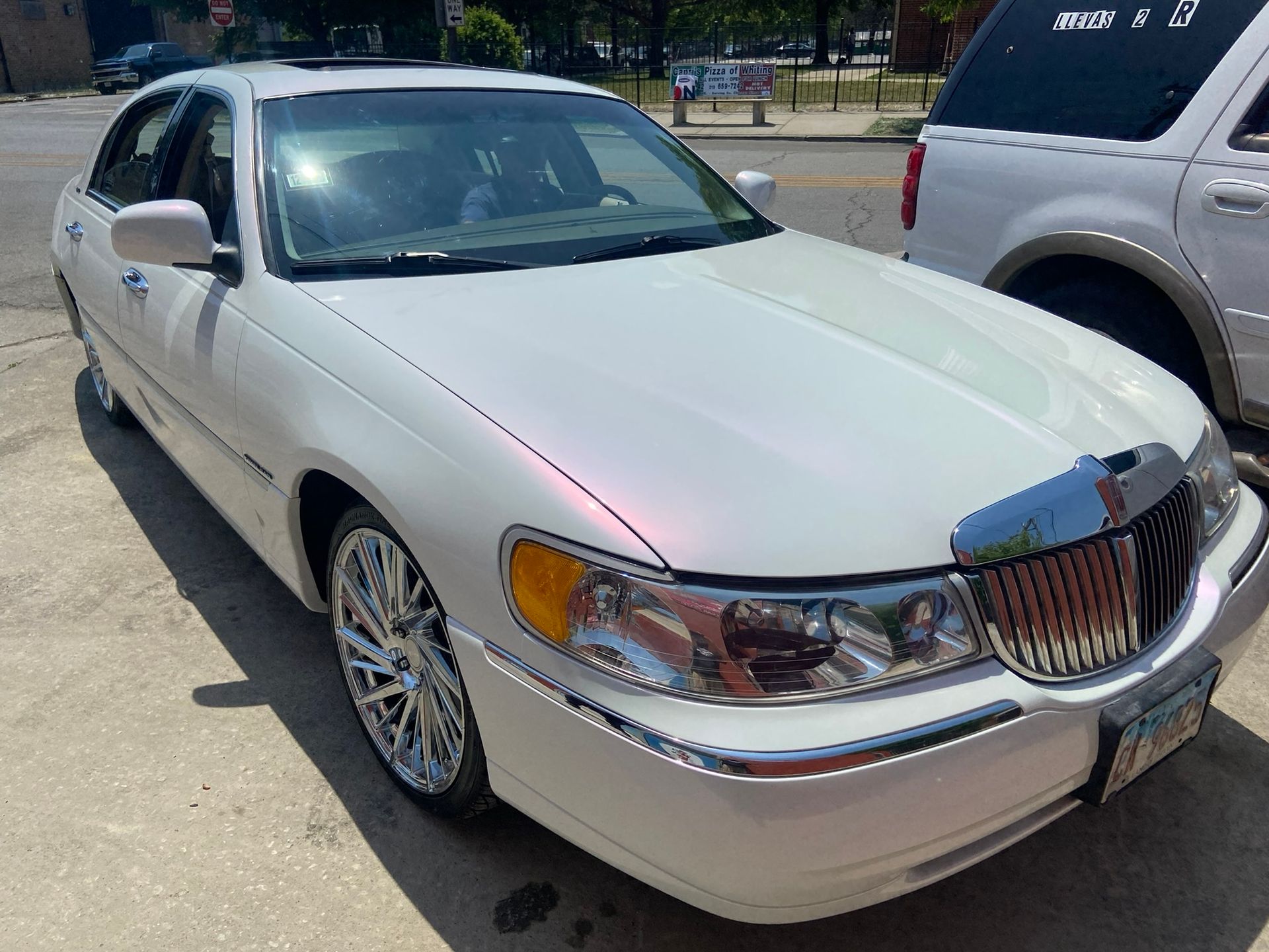 A White Lincoln Town Car Is Parked on The Side of The Road — Chicago, IL — Ecuamex Autobody Inc.