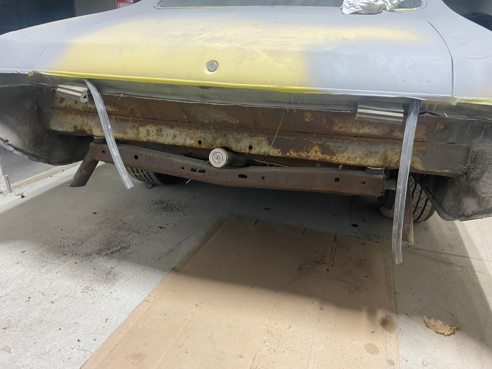 A Yellow Car Is Sitting on A Wooden Floor in A Garage — Chicago, IL — Ecuamex Autobody Inc.