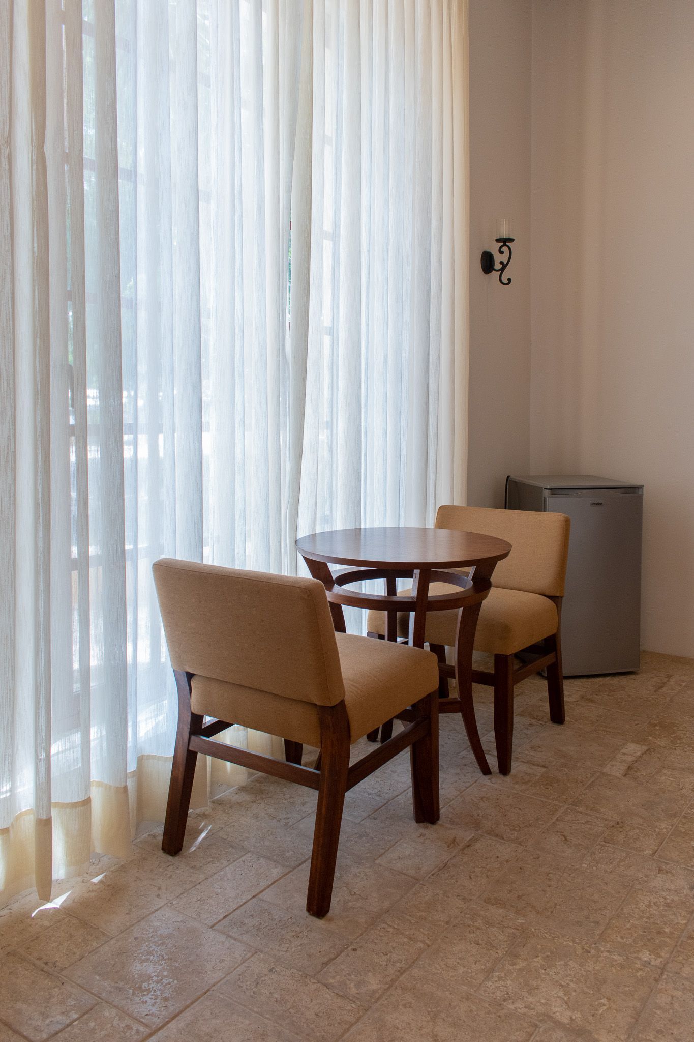 Una habitación con dos sillas y una mesa frente a una ventana.