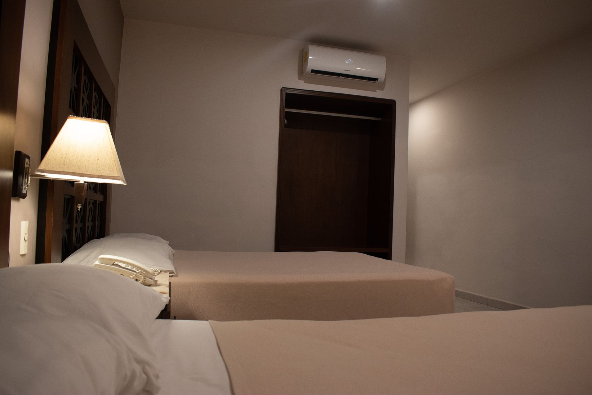 Una habitación de hotel con dos camas y una lámpara.