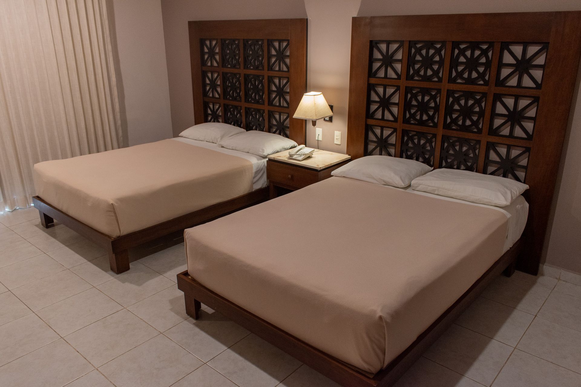 Una habitación de hotel con dos camas y una mesita de noche.