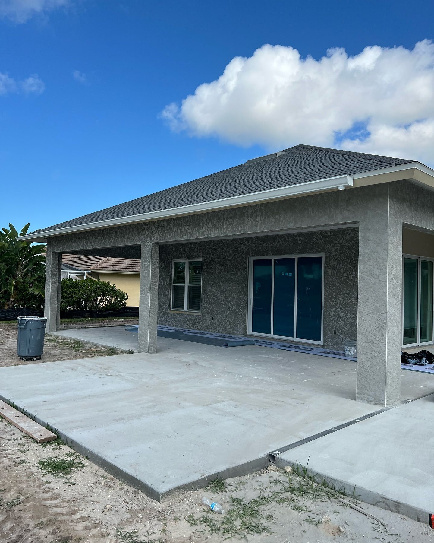 A house under construction with a concrete patio in front of it