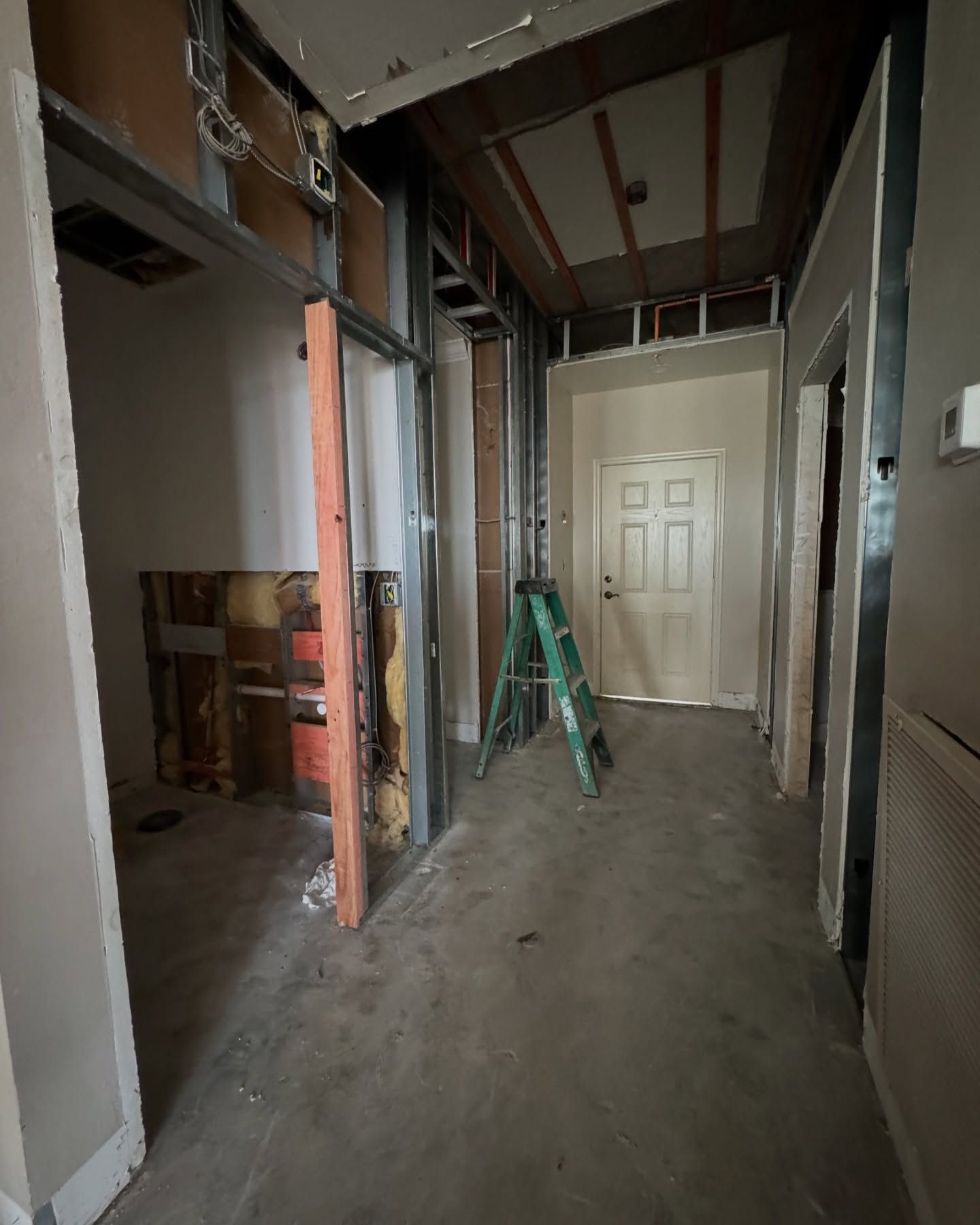 An empty hallway with a green ladder in the middle
