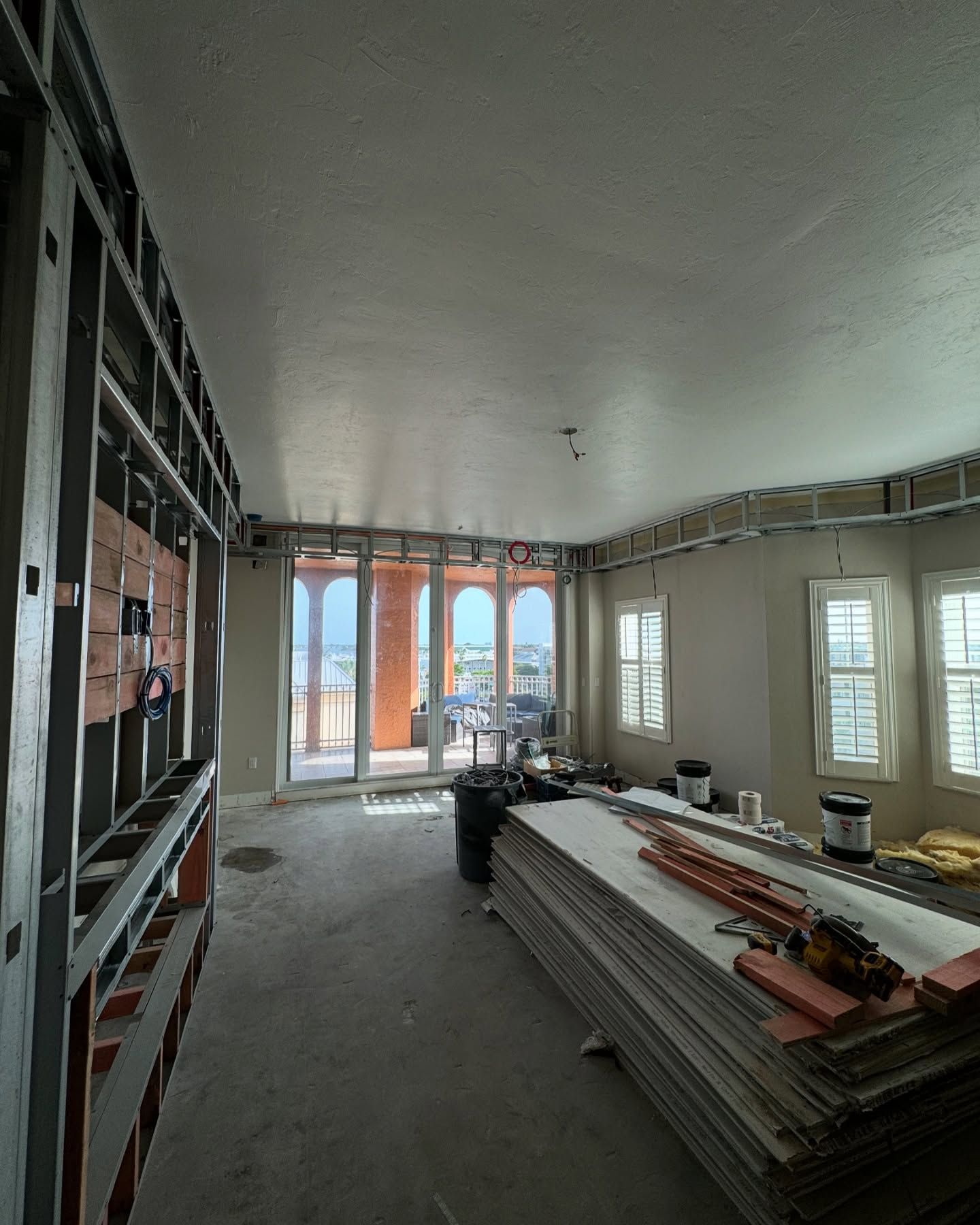 A large room with a lot of windows and a stack of wood.