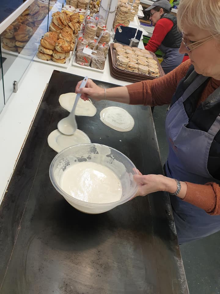 Bakestone Wales | A woman is mixing a batter in a bowl with a spoon.