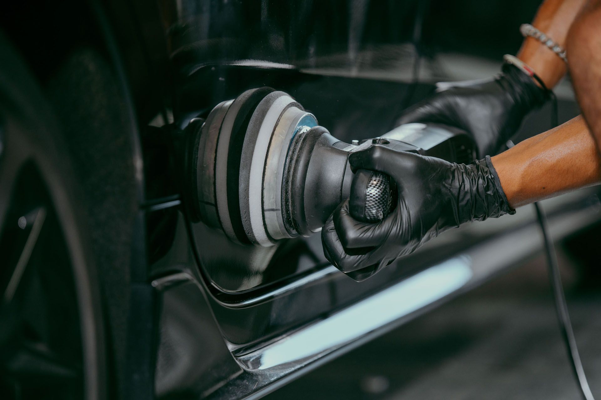 A person is polishing a car with a machine.