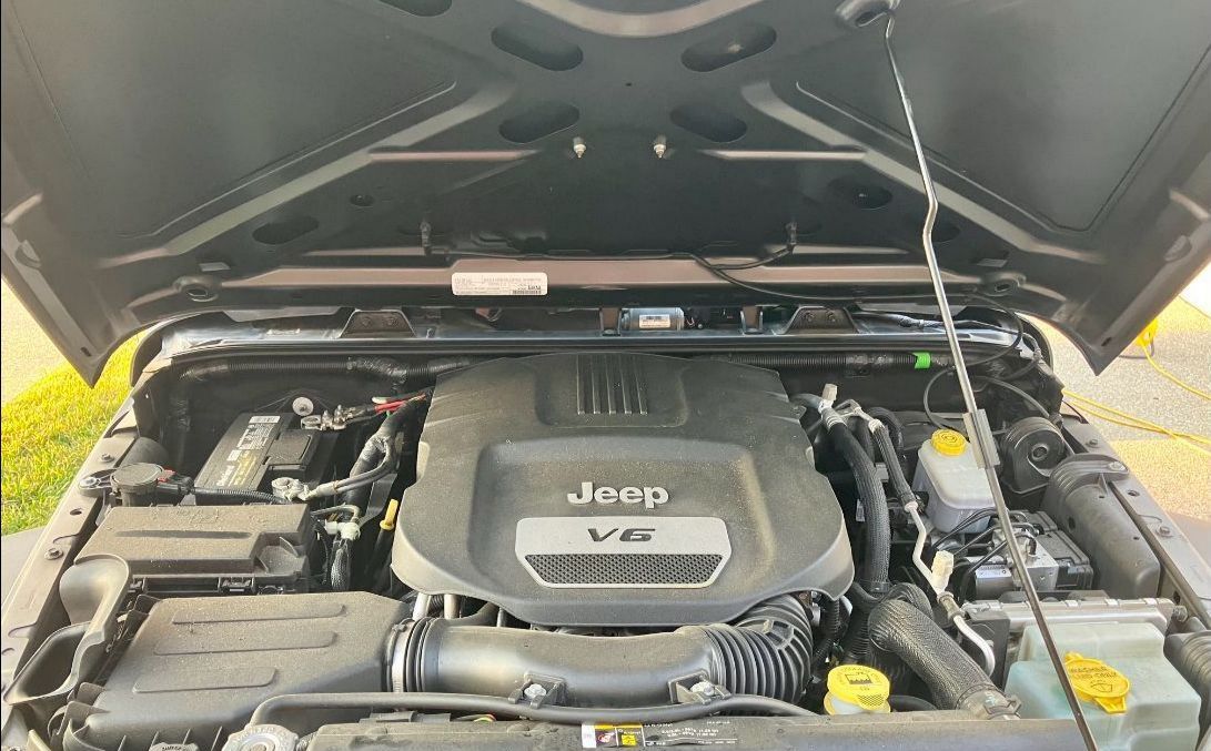 The engine of a jeep with the hood open before detailing