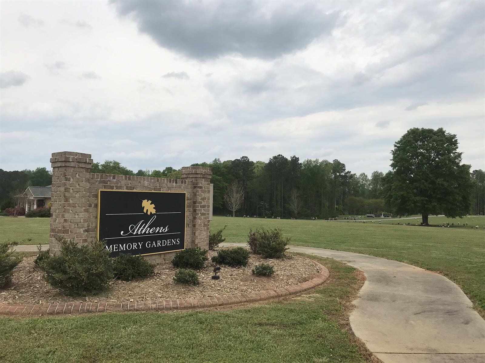 A sign that says welcome is in the middle of a grassy field