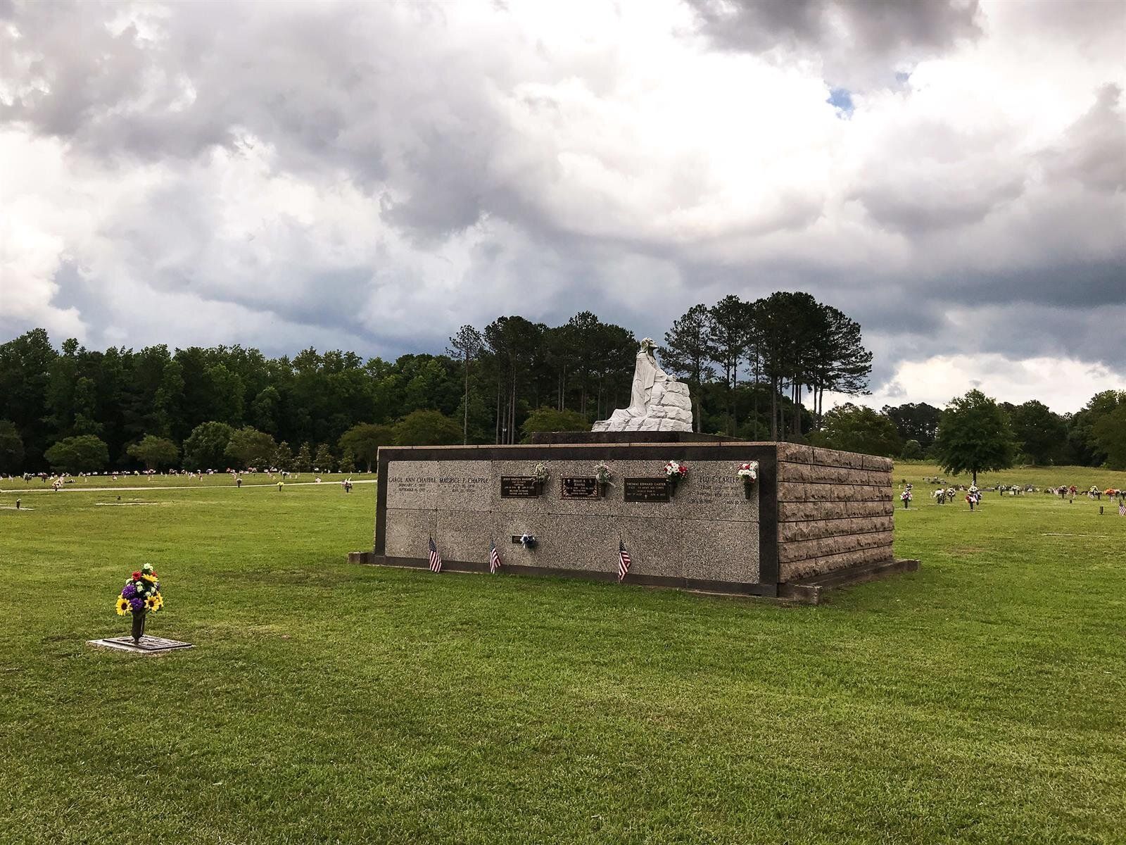A small building is sitting in the middle of a grassy field.