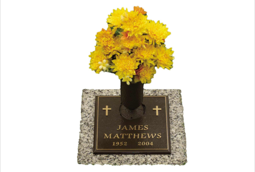 A gravestone for james matthews with yellow flowers in a vase